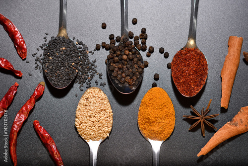 Top viewl group of spices, sesame, pepper, turmeric, cayenne pepper on spoon