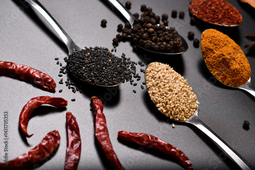 Horizontal group of spices, sesame, pepper, turmeric, cayenne peper