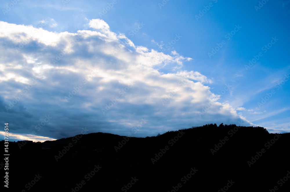 Dramatic Clouds Over Dark Hilly Silhouette Landscape