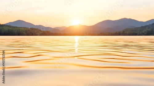 Obraz na płótnie A peaceful sunset over a still lake with a distant mountain range w salonie