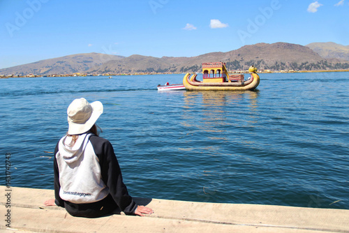 turista em ilha de totora no lago tiricaca, peru 