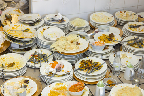 Canvas Print Pile of dirty plates and cutlery chaos with leftovers on the Kitchen Table