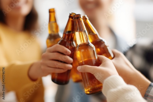close-up of group of friends toasting with beer bottles at bachelor party