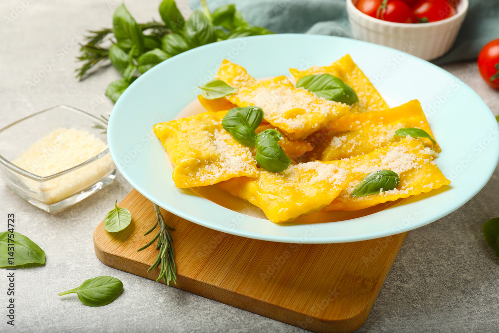 Delicious ravioli with cheese and basil served on grey table, closeup Delicious ravioli with cheese and basil served on grey table, closeup
