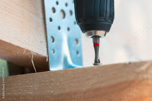 A drill bit is being used to drill a hole in a piece of wood