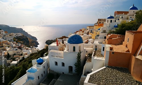 Scenic view of Santorini with white buildings and blue domes overlooking the sea at sunset