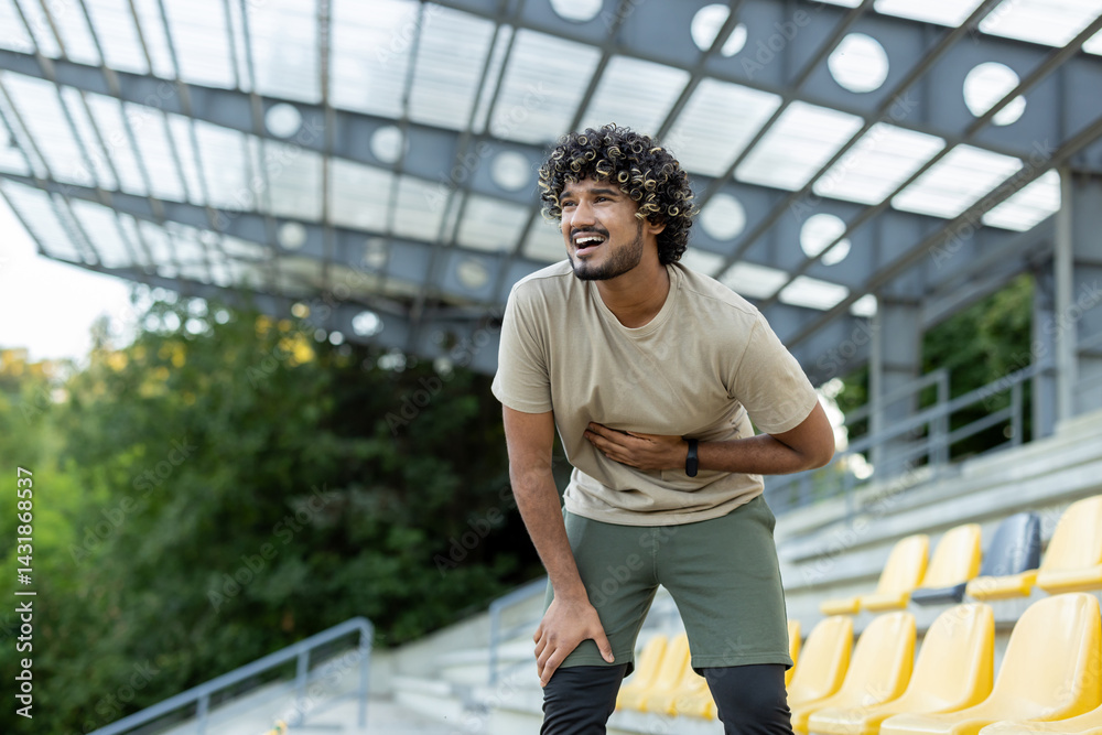 Athlete suffering from stomach pain, man holding side of stomach during active physical exercise and jogging.