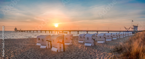 Zinnowitz, Usedom, Deutschland – Seebrücke mit Tauchgondel im goldenen Morgenlicht des Frühlings. Sonnenaufgang über der Ostsee, ruhige See, goldener Sand und erwachende Natur.