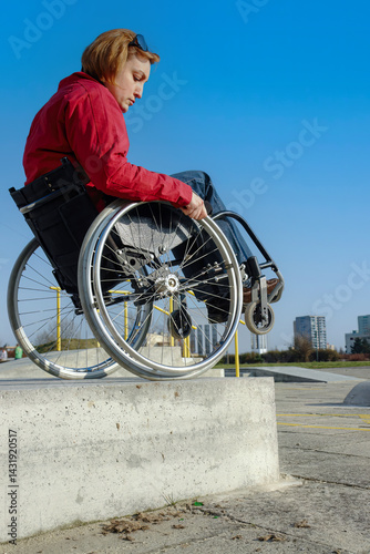 Handicapped woman on wheelchair going down the high concrete kerb