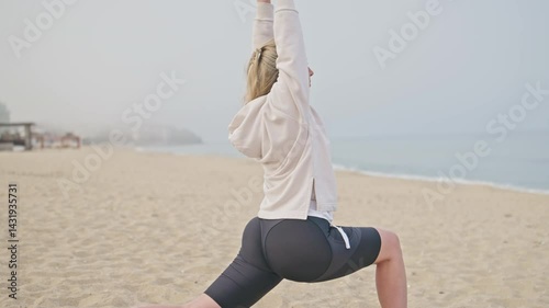 Side view stretching legs and body woman runner on the beach. Wellness, warm up