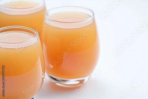 Three glasses of amber-colored juice
