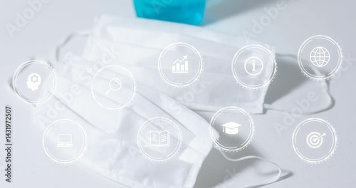 Two white masks floating on white surface, featuring nine semi transparent education and tech icons