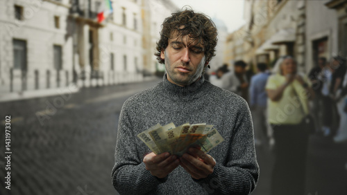 Hispanic man counts czech koruna banknotes on city street outdoors showing financial concept.