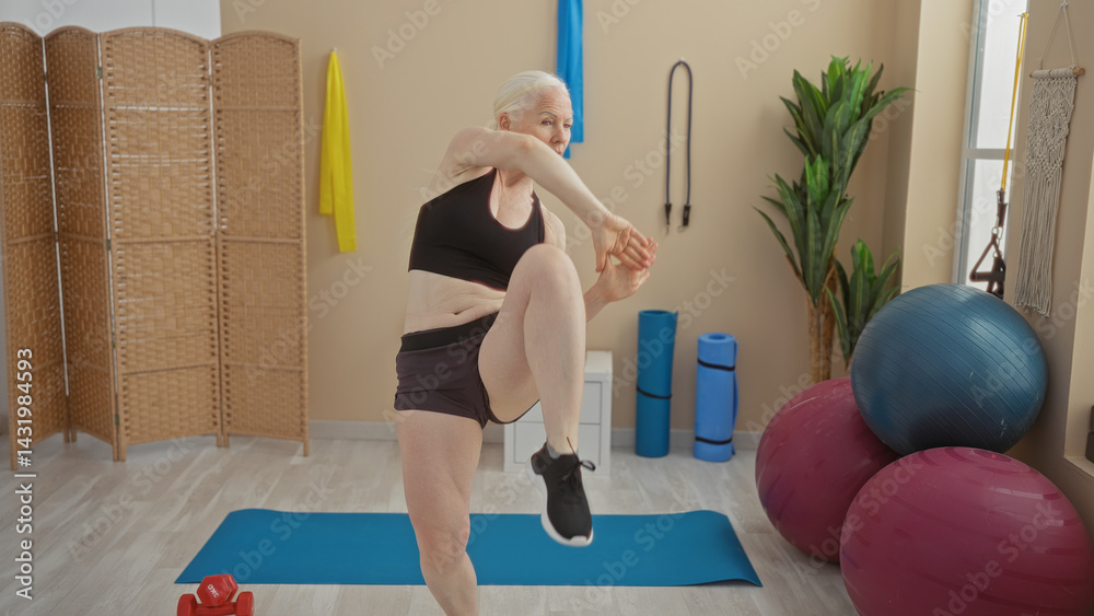 Woman exercising in a gym with albinism performing a dynamic martial arts move surrounded by fitness equipment, showcasing strength, agility, and empowerment in an indoor setting.