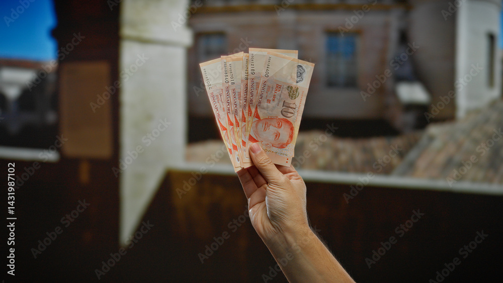 Man holding singapore banknotes in urban outdoor setting showcases financial transaction and international business atmosphere.