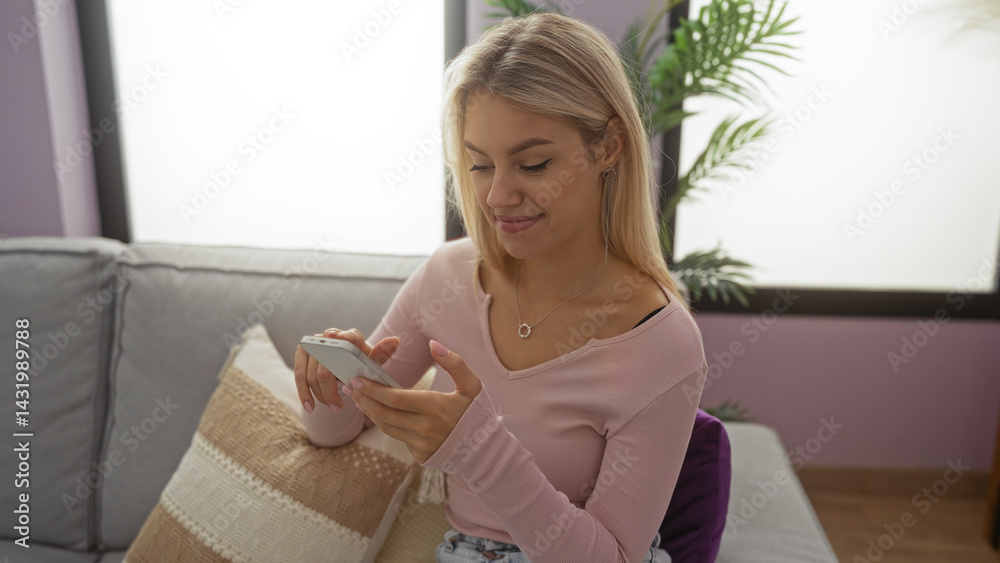 Woman using smartphone seated on cozy sofa in stylish living room with decorative plants and soft cushions showcasing a serene and modern home environment.