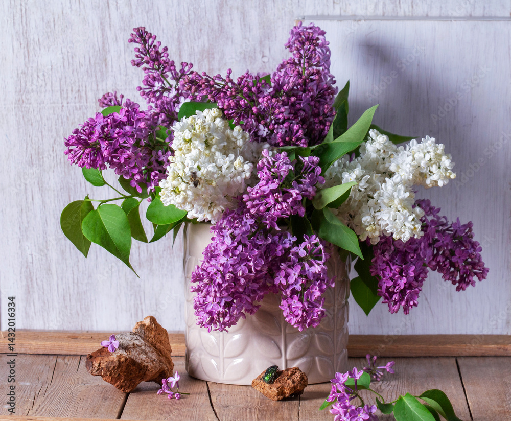 Bouquet of multi-colored lilacs, wood chips and insects on a light background.