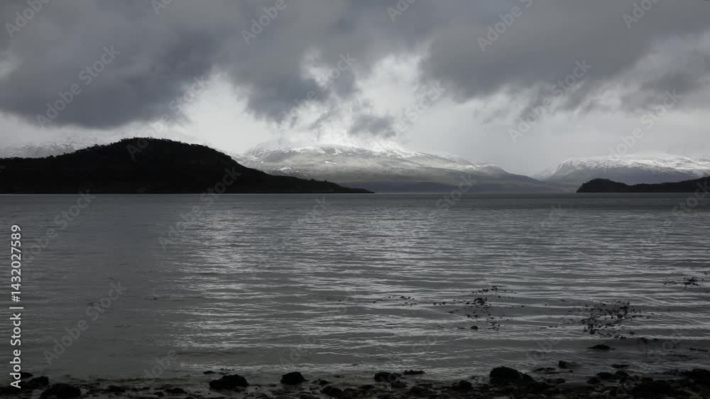 Panorama view of the alpine landscape. View of the calm lake and Andes mountains under a cloudy and stormy sky in Tierra del fuego national park, Patagonia Argentina. 
