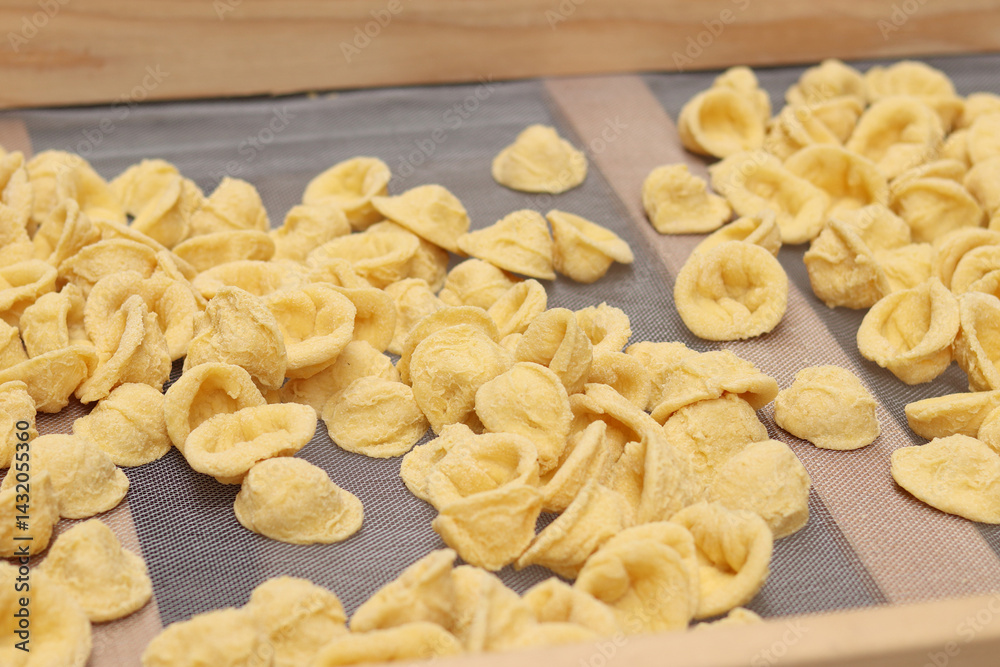 Orecchiette, a type of Italian pasta. Demonstration of the famous Apulian orecchiette common in Italy. Varieties of fresh pasta. Italian pasta in the shape of small ears. Handmade orecchiette pasta