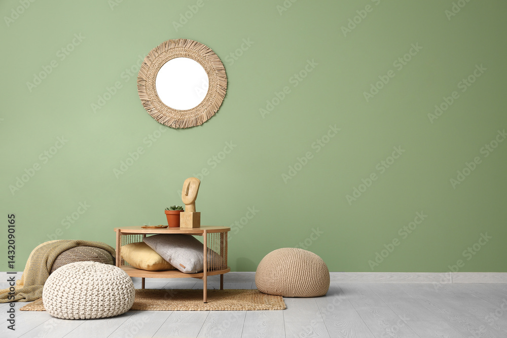 Coffee table with pillows and poufs near green wall
