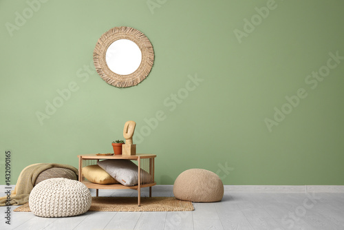 Obraz na płótnie Coffee table with pillows and poufs near green wall w salonie