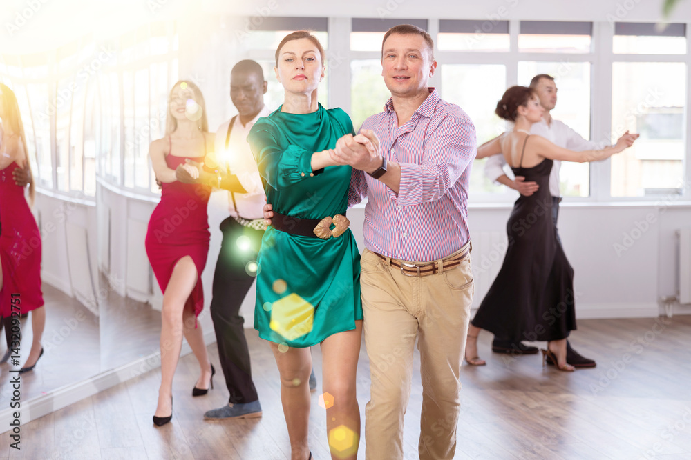 Naklejka premium Energy man and woman are dancing classic version of waltz in couple during lesson at studio. Leisure activities and physical activity for positive people.