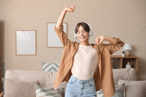 Happy young woman in headph...