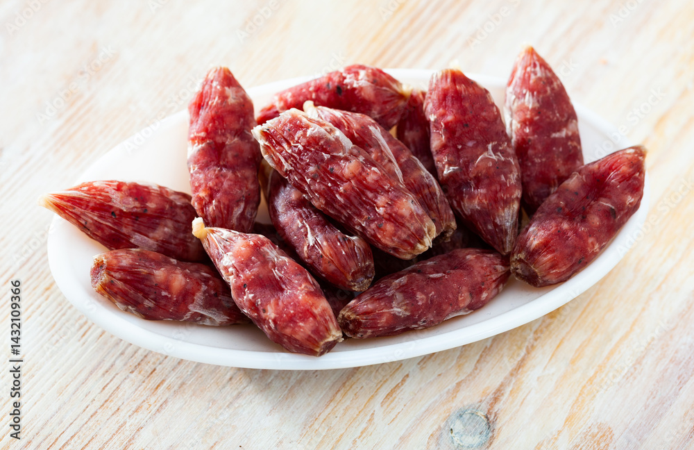 Traditional Catalan dry cured mini sausage secallona on wooden background Traditional Catalan dry cured mini sausage secallona on wooden background