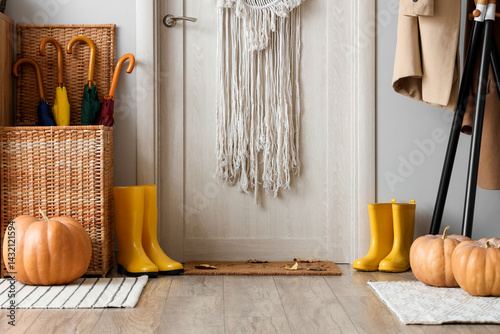 Foto Interior of hallway with door, gumboots and pumpkins