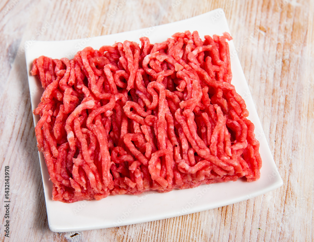Raw ground meat of pork and beef ready for cooking on wooden surface.. Raw ground meat of pork and beef ready for cooking on wooden surface..