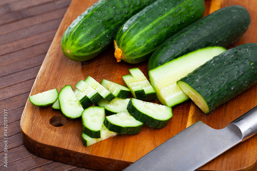 Vegetable ingredients for cooking, sliced cucumbers on wooden table Vegetable ingredients for cooking, sliced cucumbers on wooden table