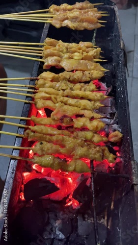 The process of grilling chicken satay, satay is made from chicken meat that is cut into small pieces then skewered on skewers, and grilled over hot coals. popular food in Asia