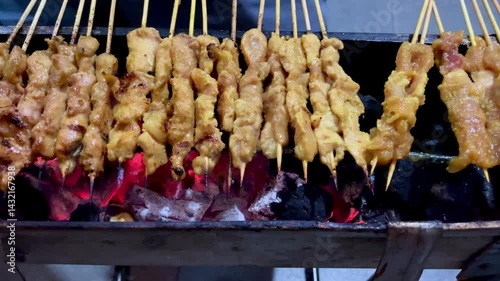 The process of grilling chicken satay, satay is made from chicken meat that is cut into small pieces then skewered on skewers, and grilled over hot coals. popular food in Asia