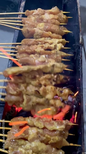 The process of grilling chicken satay, satay is made from chicken meat that is cut into small pieces then skewered on skewers, and grilled over hot coals. popular food in Asia