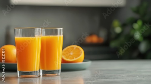 Refreshing Glasses of Orange Juice on a Stylish Table with Fresh Oranges in the Background