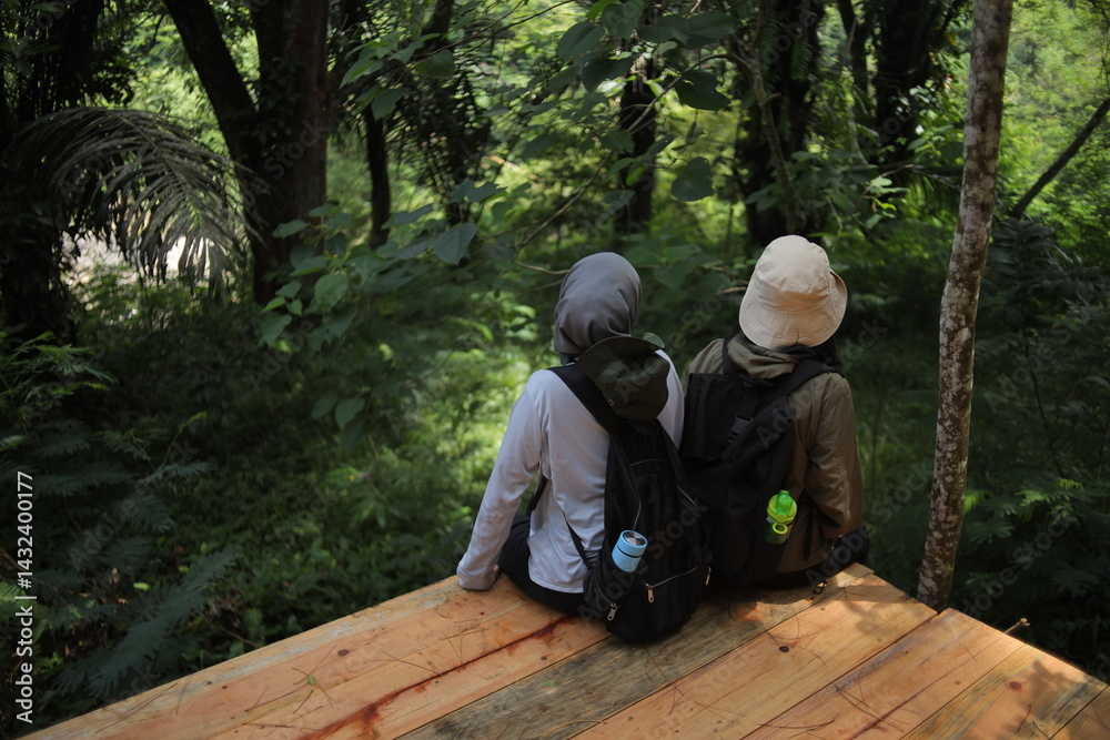 Two adventurous friends sit quietly in the forest, soaking in the peaceful natural surroundings. Two adventurous friends sit quietly in the forest, soaking in the peaceful natural surroundings.