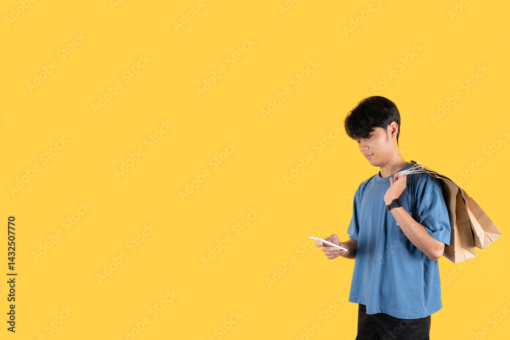 A man with brown shopping bag on his shoulder while holding a phone A man with brown shopping bag on his shoulder while holding a phone