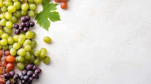 Fresh assortment of green, red, and purple grapes with grape leaves on a light background, close-up view, and vibrant and healthy fruits concept.