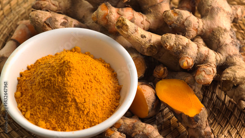 Turmeric powder in a cup and fresh turmeric