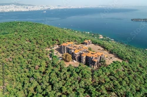 Buyukada Greek Orphanage. Aerial view of the Buyukada Greek Orphanage on a coastal hill surrounded by lush vegetation with the sea in the background. Istanbul, Turkey.