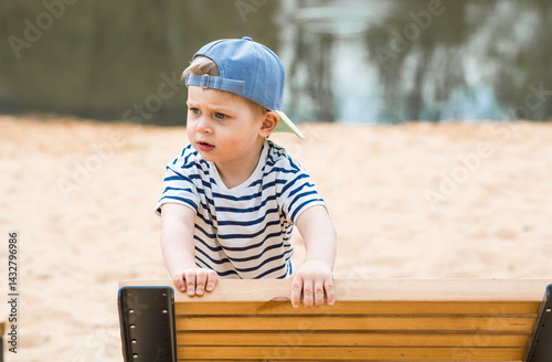 Summer lifestyle. A cute little boy is having fun playing in a modern outdoor playground. The concept of family entertainment and leisure.