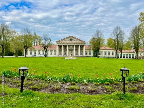 Taujenai manor and park Neoclassical manor with a symmetrical facade features a central section with four large columns supporting a triangular pediment.  photo