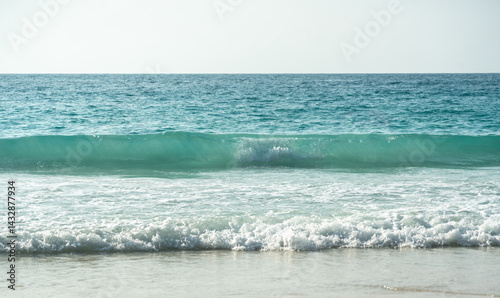 Obraz na płótnie Clear turquoise waves gently crashing on a peaceful sandy beach at a tropical island coastline w salonie