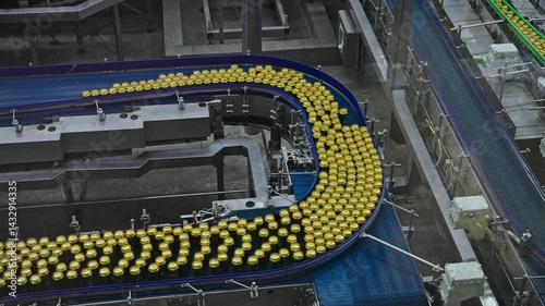 Modern automated beer factory with canning production line. Hundreds aluminum cans move fast conveyor belt clean industrial facility. High-tech beverage manufacturing process.