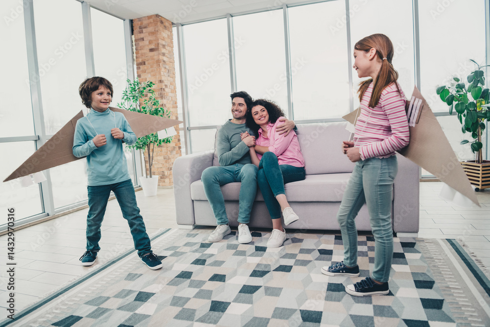 Fototapeta premium Happy family bonding indoors with children playing creatively in a well lit modern living room during a joyful daytime moment