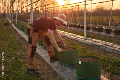 Obraz na płótnie Male gardener with hat working in a blueberries organic farm. w salonie