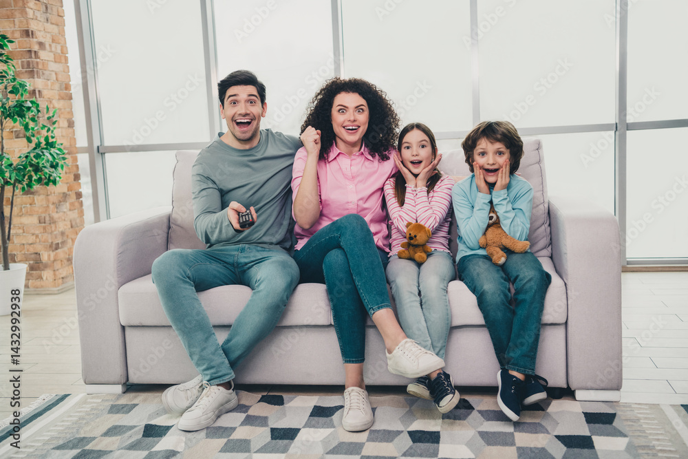 Cheerful family of four enjoying time together on the sofa at home during a bright day, sharing fun moments and bonding. Cheerful family of four enjoying time together on the sofa at home during a bright day, sharing fun moments and bonding.