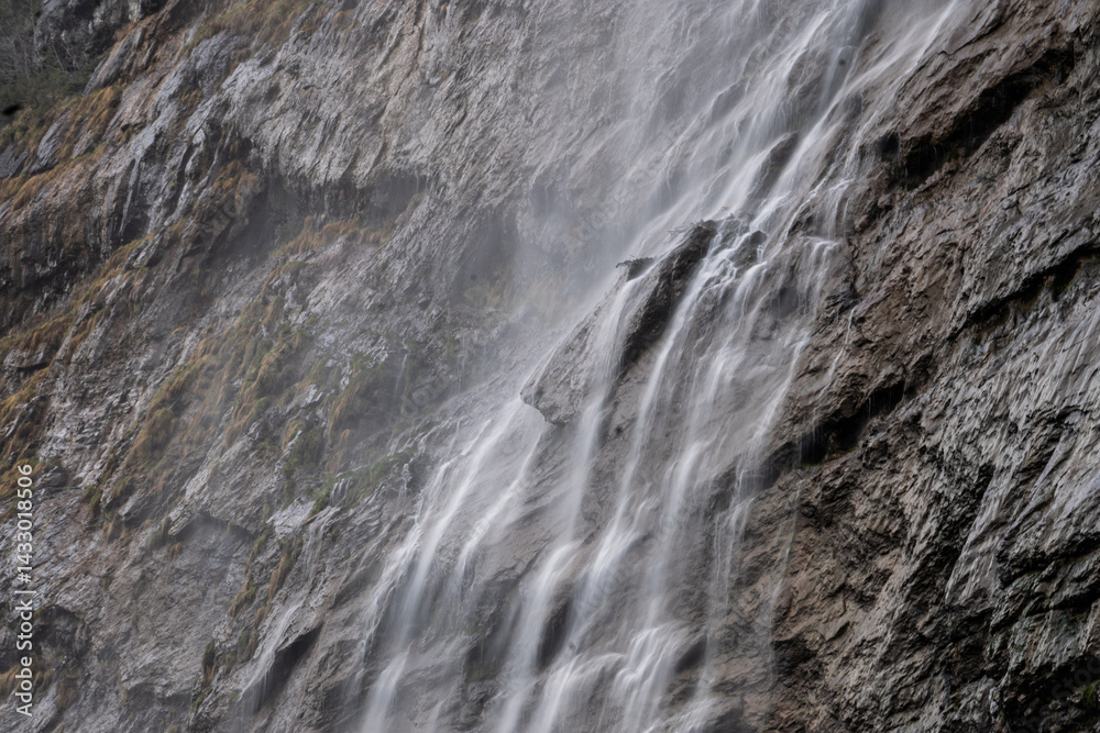 Obraz premium Crystal-clear waterfall flowing over rocks – scenic nature landscape