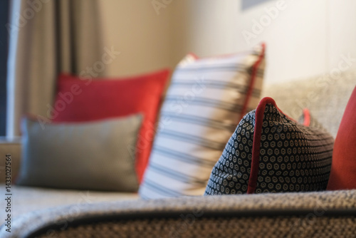 Luxurious mini suite stateroom cabin room onboard luxury cruise ship cruiseship ocean liner with bedroom and living area in red and creme with wood in modern Art Deco interior design