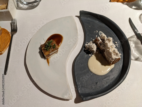 Two elegant dishes are showcased on a table, representing a creative and exquisite fine dining experience.
